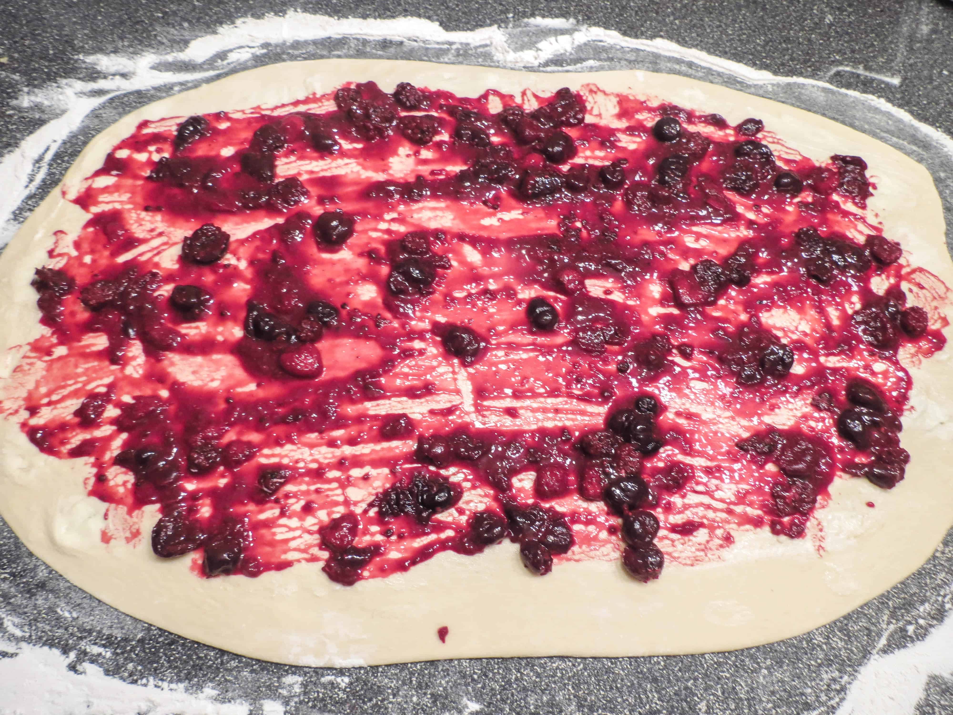 Mixed berry sweet rolls being prepared before rolling.