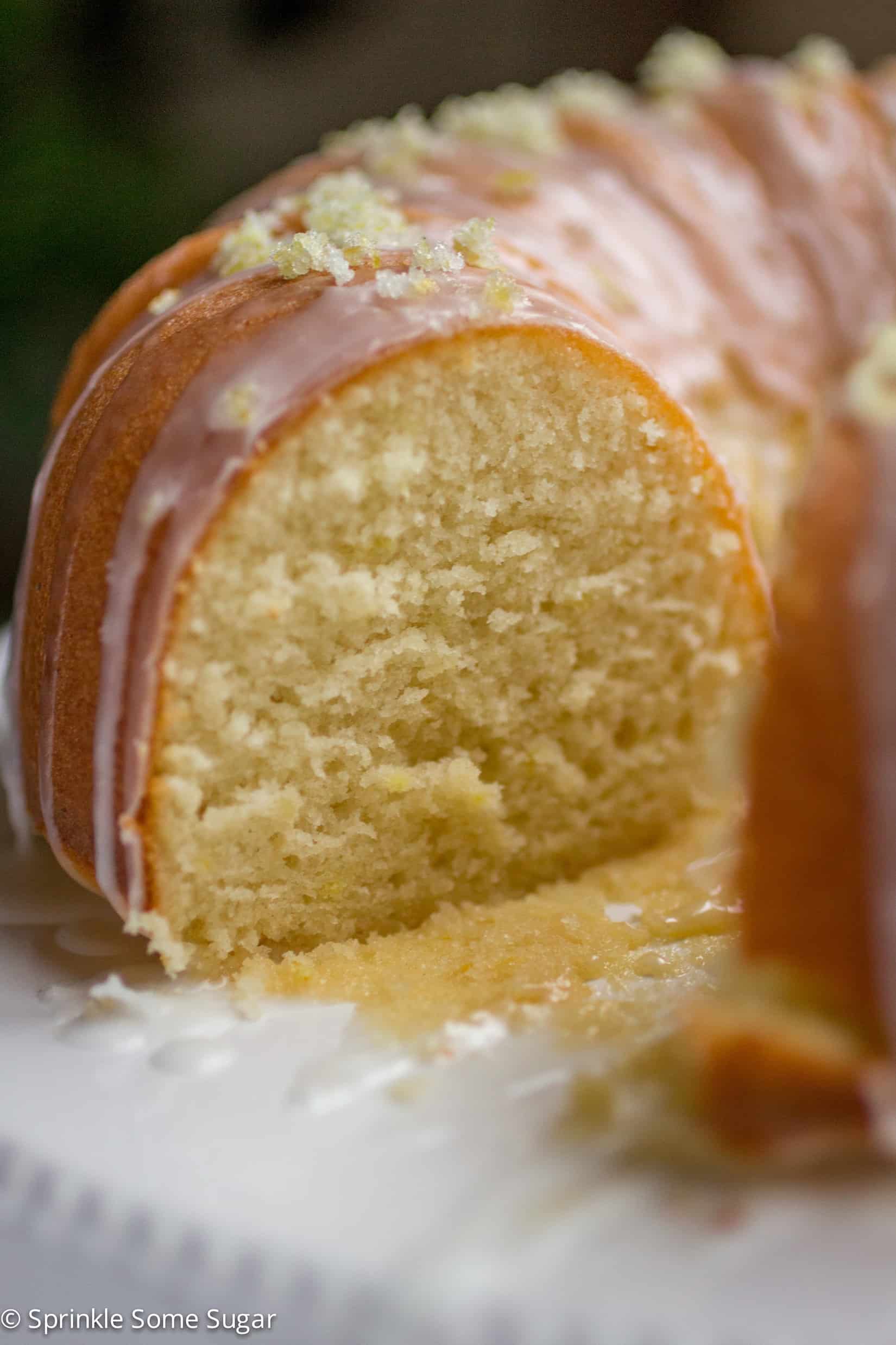 Lemon bundt cake with a slice missing revealing the soft inside.