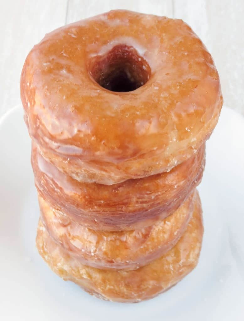 Homemade glazed biscuit donuts stacked on top of each other.