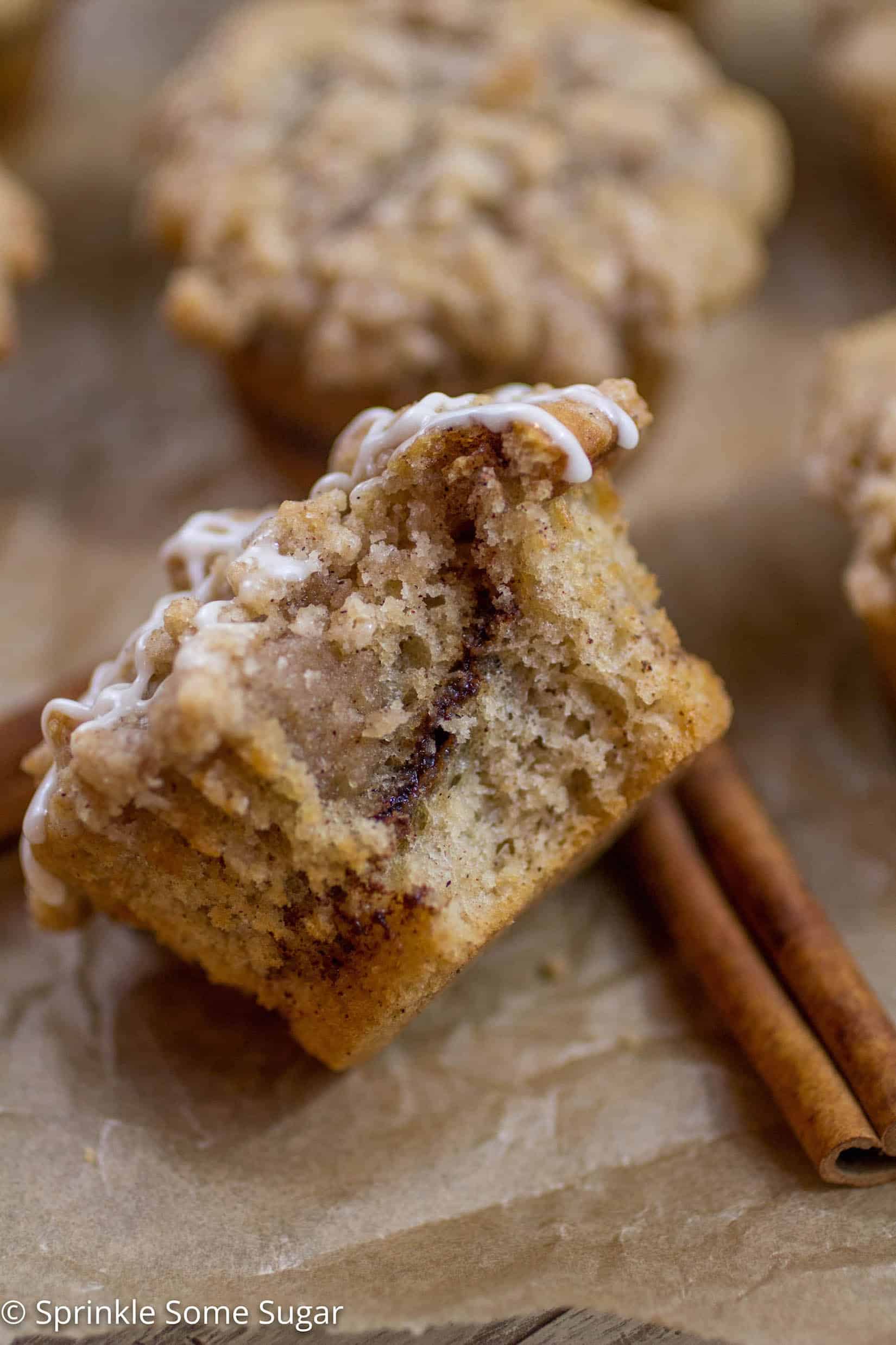 Cinnamon Swirl Coffee Cake Muffin with a bite taken out of the center to reveal the gooey cinnamon swirl inside.