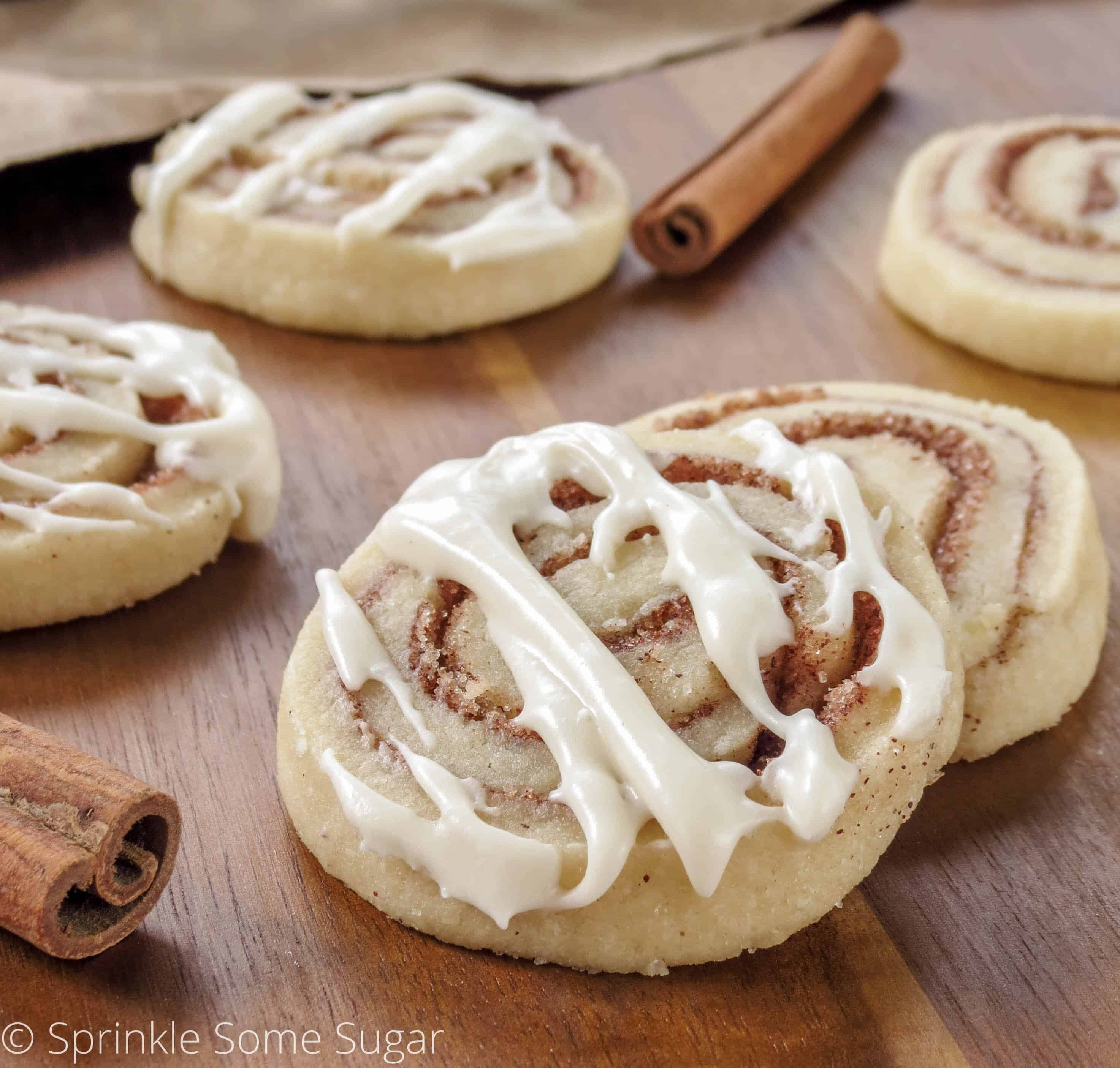 Cinnamon Roll Cookies with glaze on a cutting board.