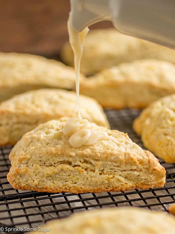 Fresh orange scones with orange glaze being drizzled on.