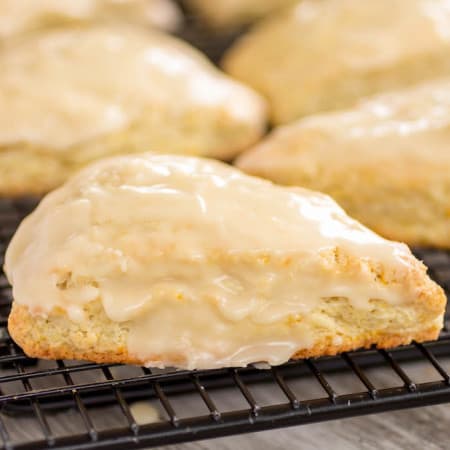 Fresh Orange Scones with glaze on top on a cooling rack.