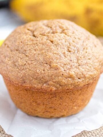 Banana muffin on a piece of parchment paper.