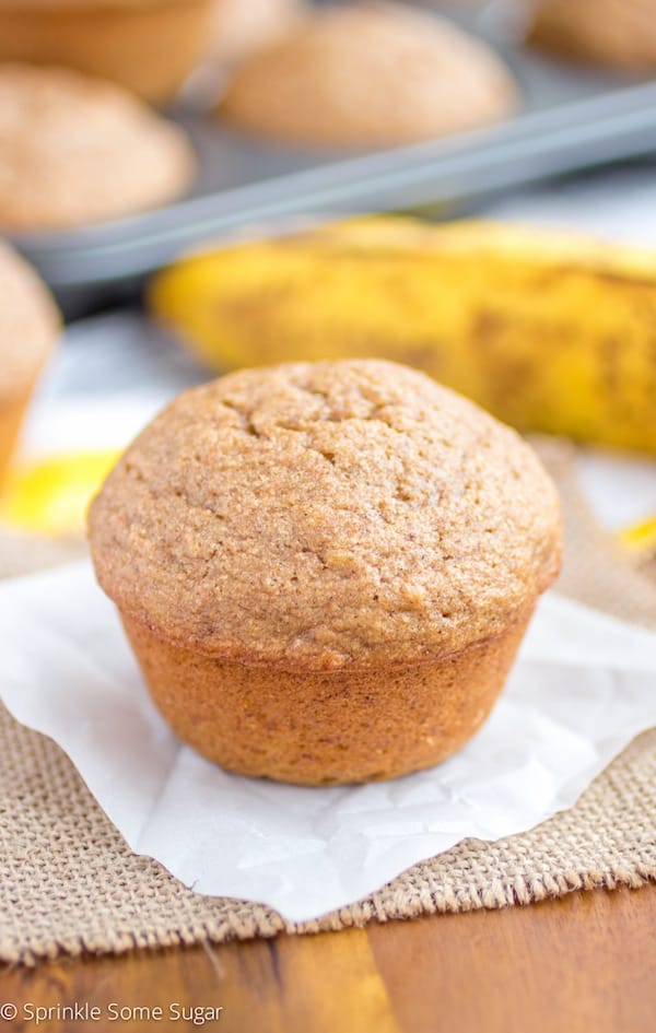 Banana muffin on a piece of parchment paper.
