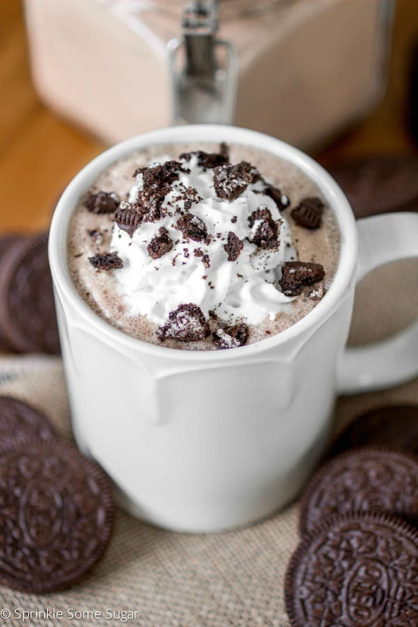 Oreo hot chocolate in a white mug with whipped cream and crushed Oreos.