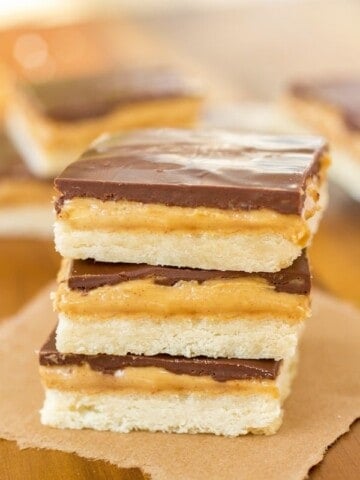 Tagalong cookie bars stacked on a piece of brown parchment paper.
