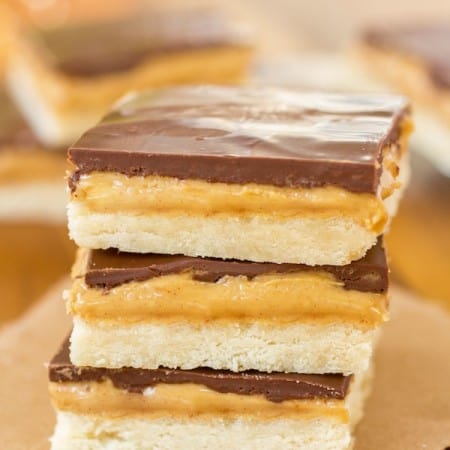 Tagalong cookie bars stacked on a piece of brown parchment paper.