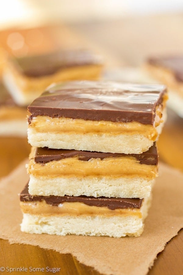 Tagalong cookie bars stacked on a piece of brown parchment paper.