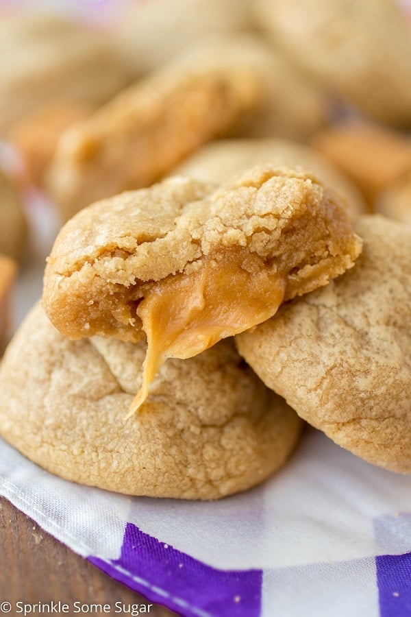 Caramel stuffed peanut butter cookie with a bite taken out to reveal gooey caramel inside.