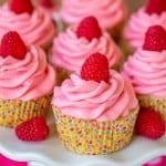 Lemon Raspberry cupcakes on a plate with polka dot wrappers.