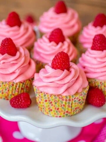 Lemon Raspberry cupcakes on a plate with polka dot wrappers.