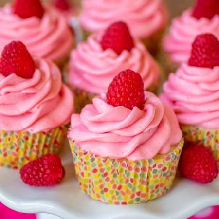 Lemon Raspberry cupcakes on a plate with polka dot wrappers.