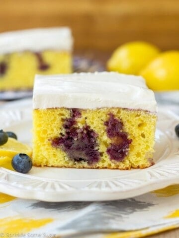 Lemon poke cake with blueberries slice on a plate.
