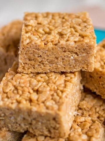Peanut butter honey Rice Krispie treats stacked on top of each other with a bite taken out.