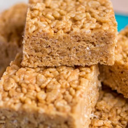 Peanut butter honey Rice Krispie treats stacked on top of each other with a bite taken out.