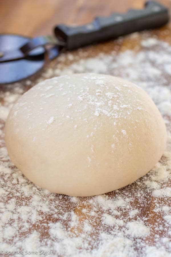 Pizza dough on floured counter.