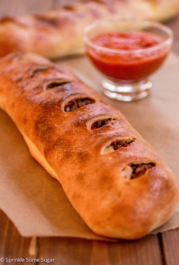 Sausage Stromboli on a piece of brown parchment paper.