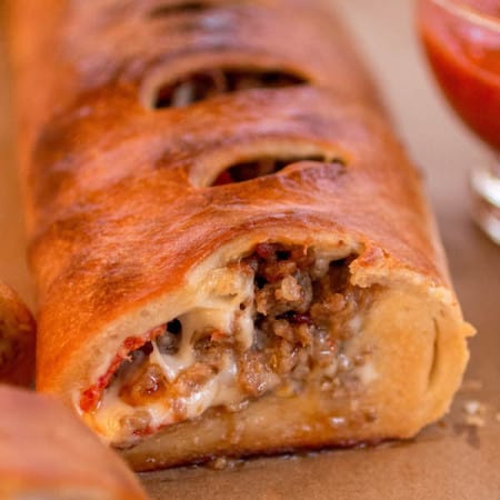 Italian sausage and provolone Stromboli with a slice cut out.