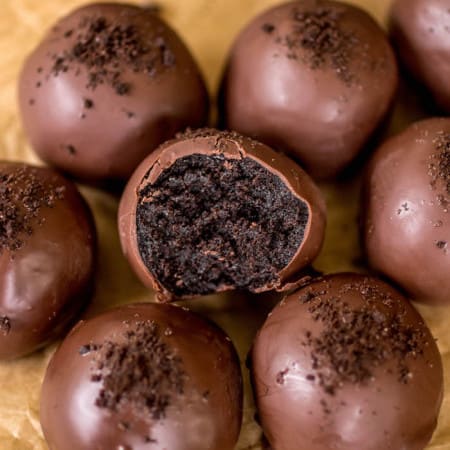 Oreo truffles on brown parchment paper half bitten.