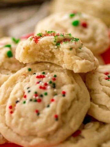 Soft amish sugar cookies stacked with the top cookie bite taken out.