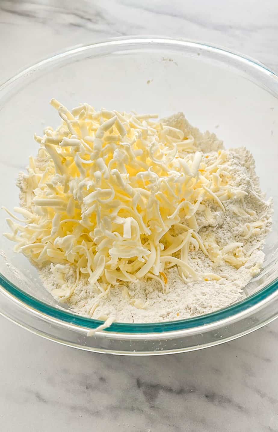 Grate frozen butter into mixture.