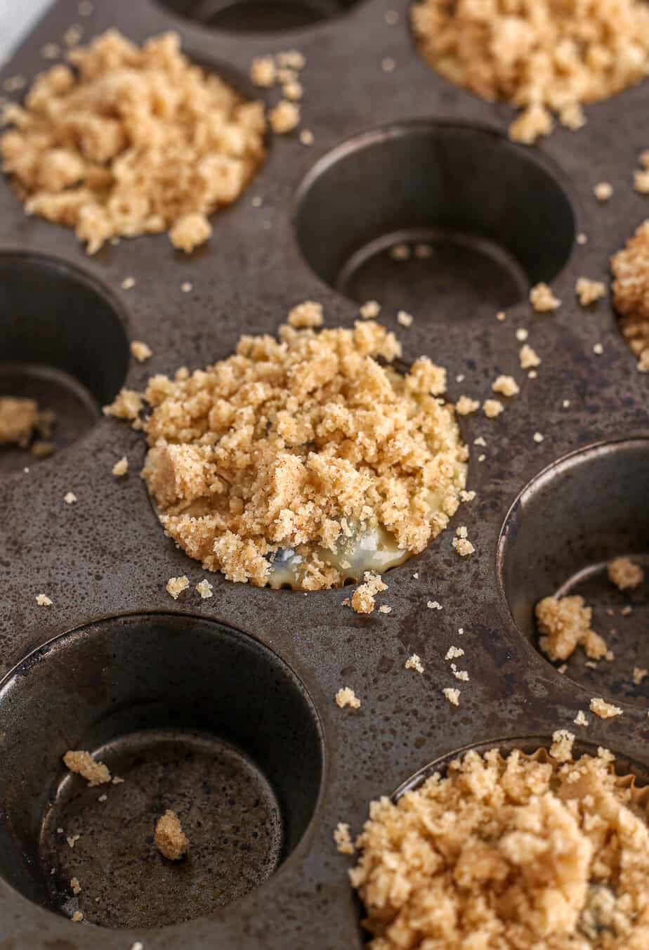 Blueberry Muffins With Crumb Topping in muffin pan before baking.