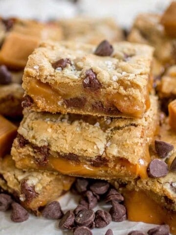 Salted caramel chocolate chip cookie bars stacked on top of one another.