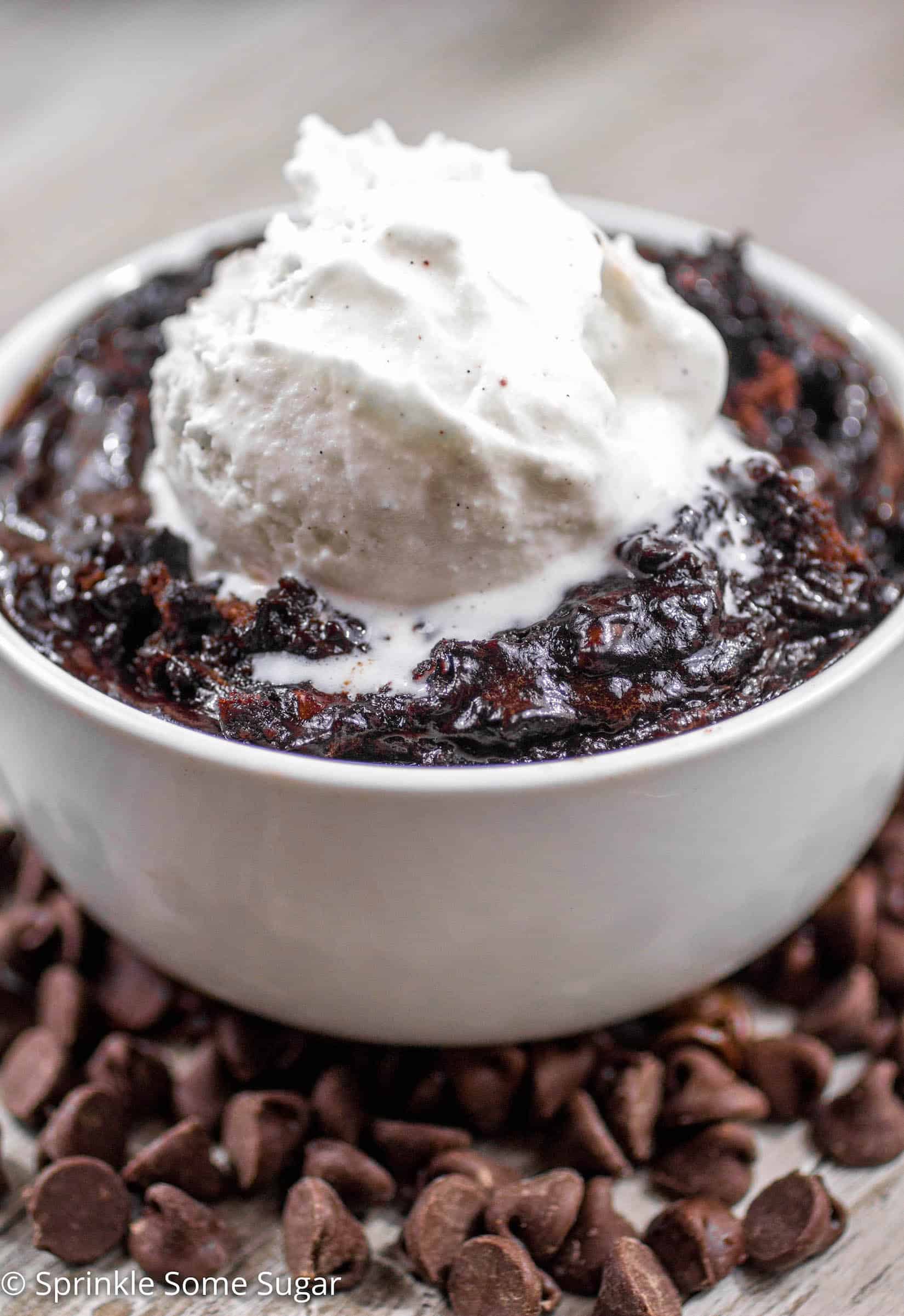 Slow Cooker Brownie Pudding in a bowl with vanilla ice cream on top.