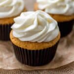 Pumpkin spice cupcakes on a piece or brown parchment paper.