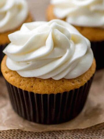 Pumpkin spice cupcakes on a piece or brown parchment paper.
