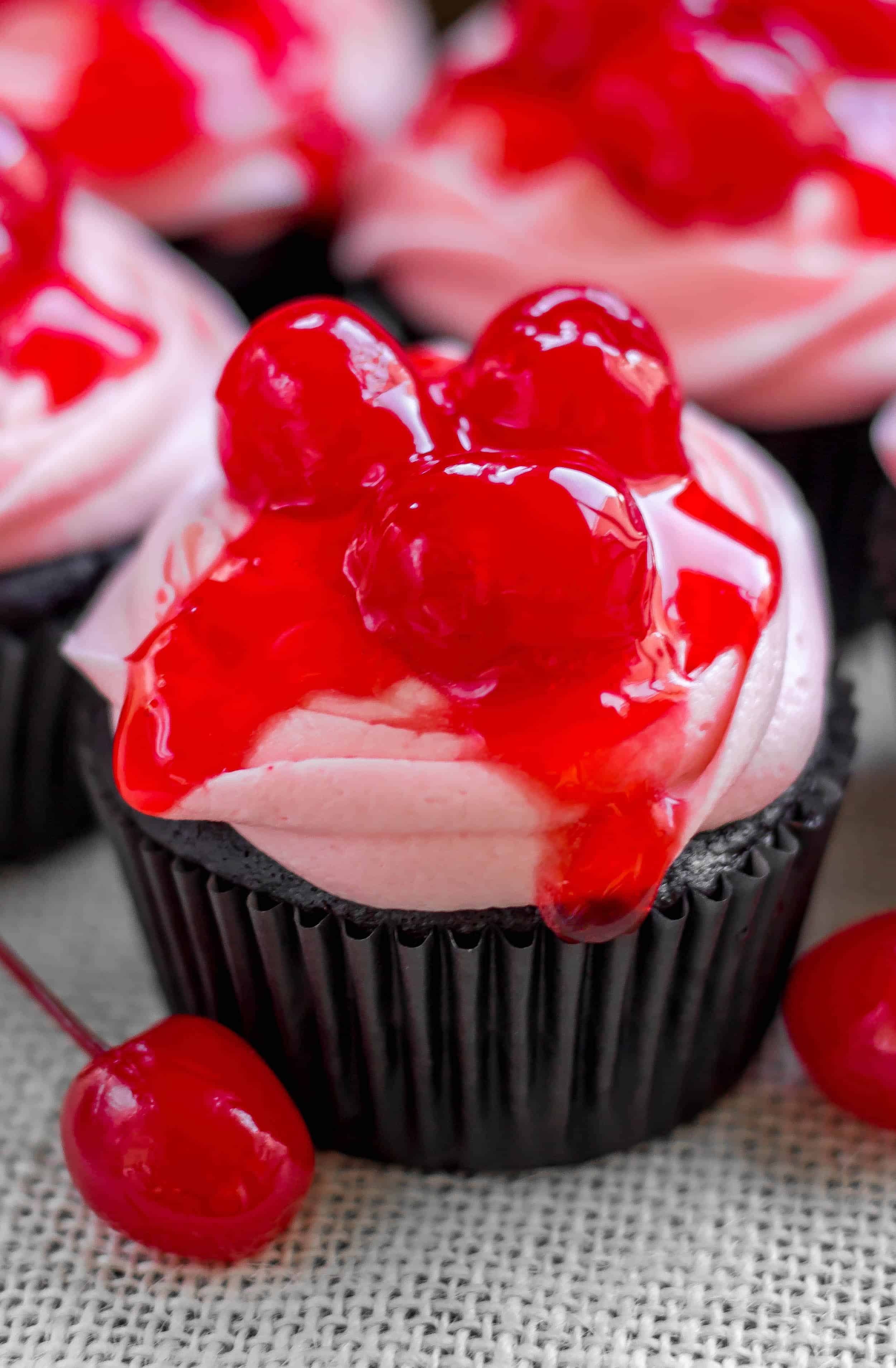 Decadent dark chocolate cupcakes topped with a sweet cherry buttercream, maraschino cherry glaze and cherries. - Sprinkle Some Sugar