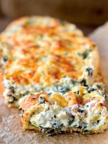 Crispy, crusty french bread gets filled with an extra creamy spinach and artichoke dip. - Spinach and Artichoke Stuffed Bread