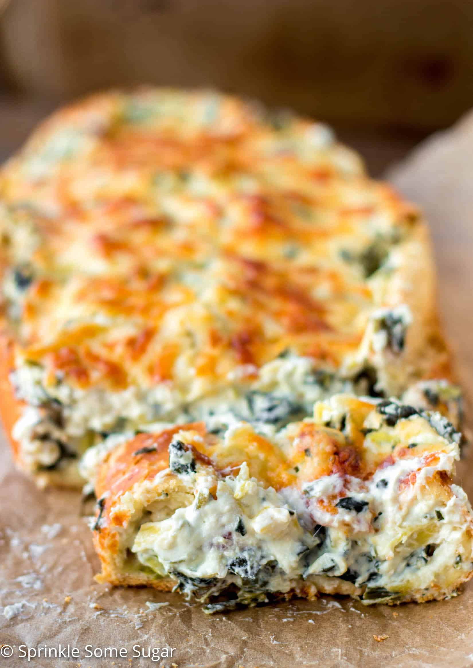 Crispy, crusty french bread gets filled with an extra creamy spinach and artichoke dip. - Spinach and Artichoke Stuffed Bread