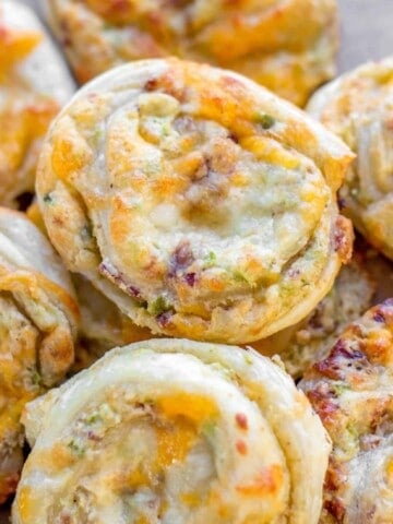 Jalapeno popper pinwheel appetizers on a plate stacked.