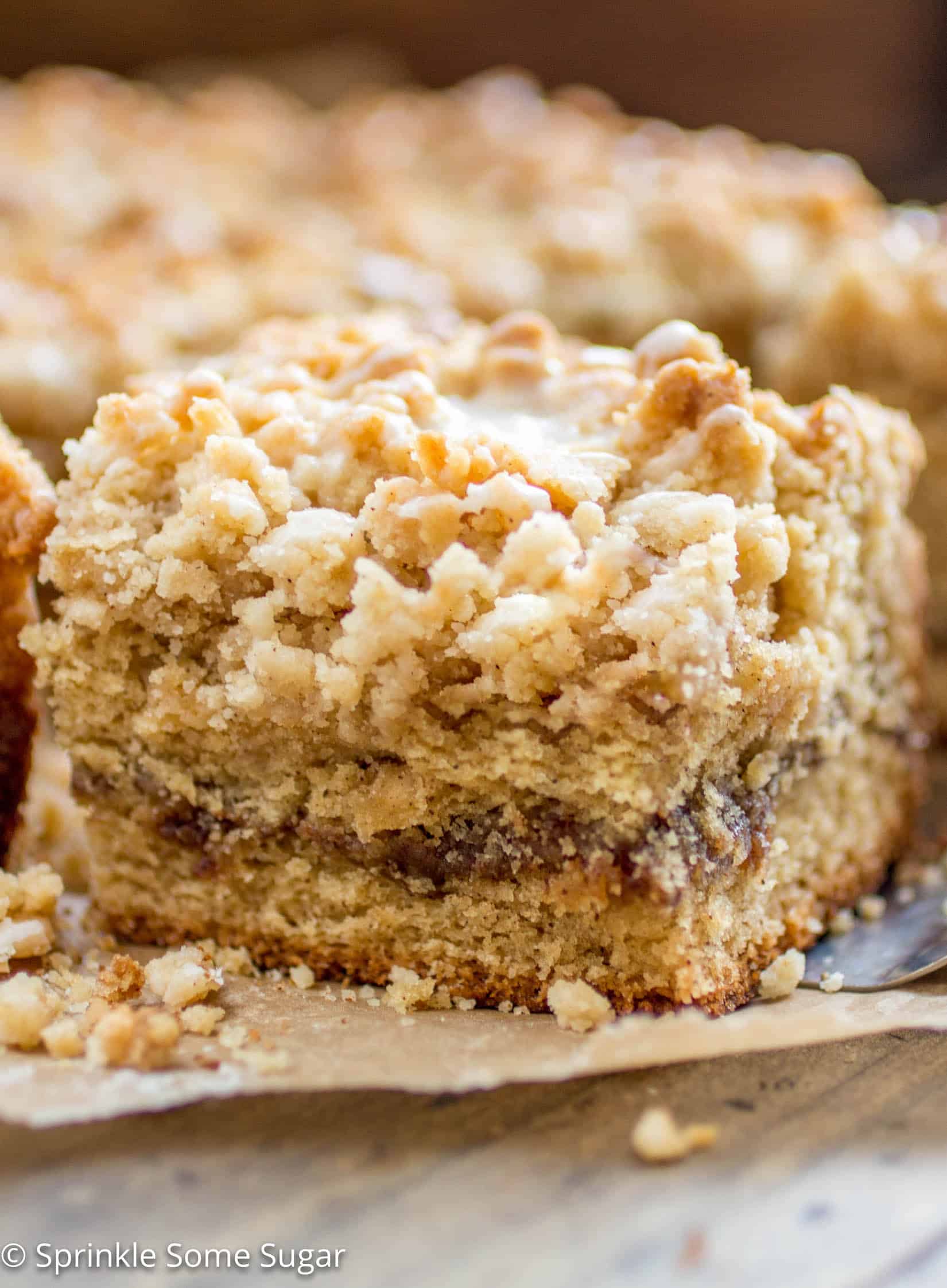 Cinnamon Swirl Coffee Cake - Soft lightly spiced coffee cake is filled with a gooey cinnamon swirl center and topped with a sweet streusel topping + vanilla glaze!