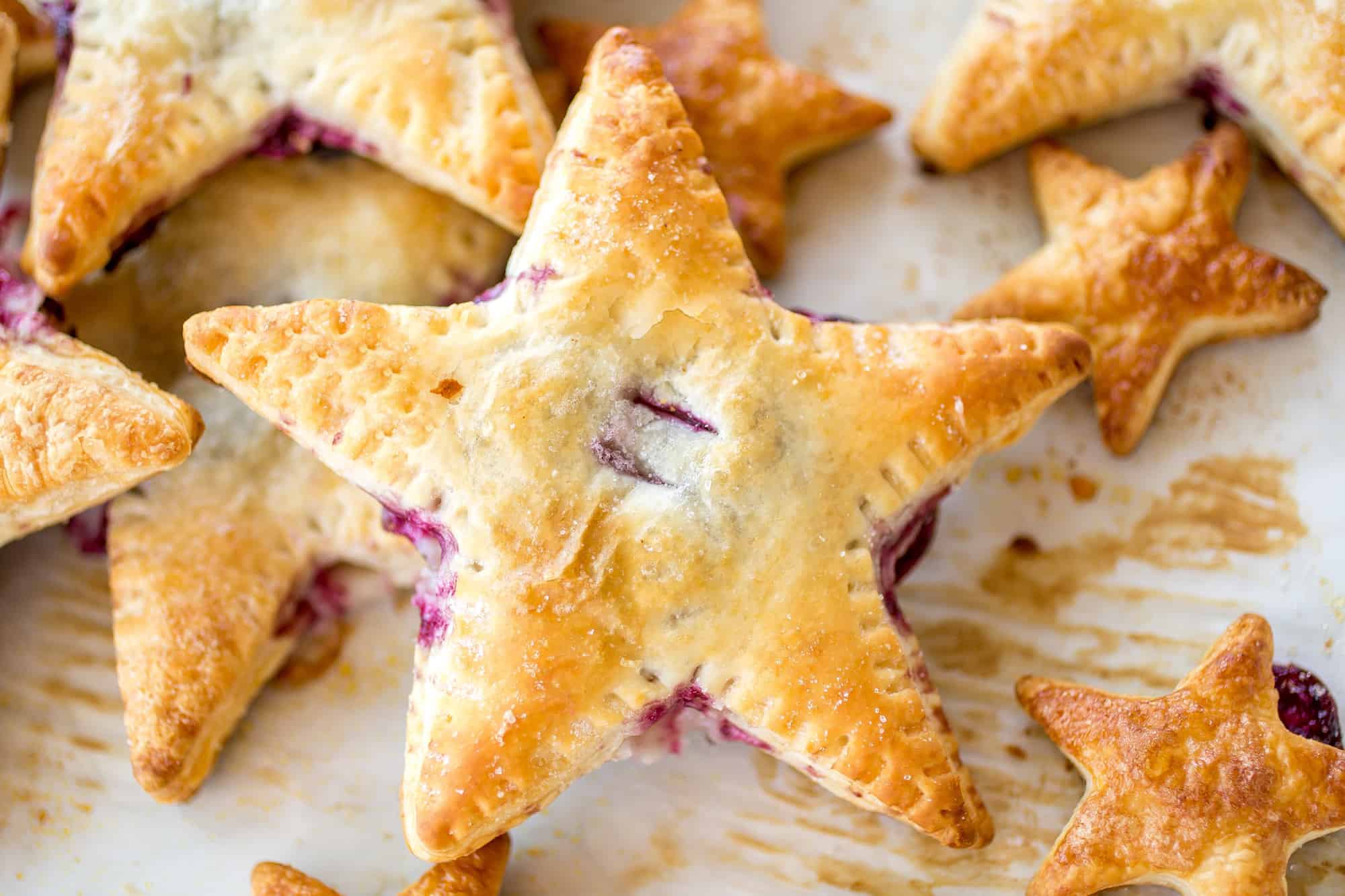 Cherries and Cream Danish Stars - These cherries and cream danishes are so much fun for the Summer holidays coming up! The dough is flakey, buttery, and crispy on the outside and the inside has a creamy cream cheese filling topped with some homemade cherry preserves!