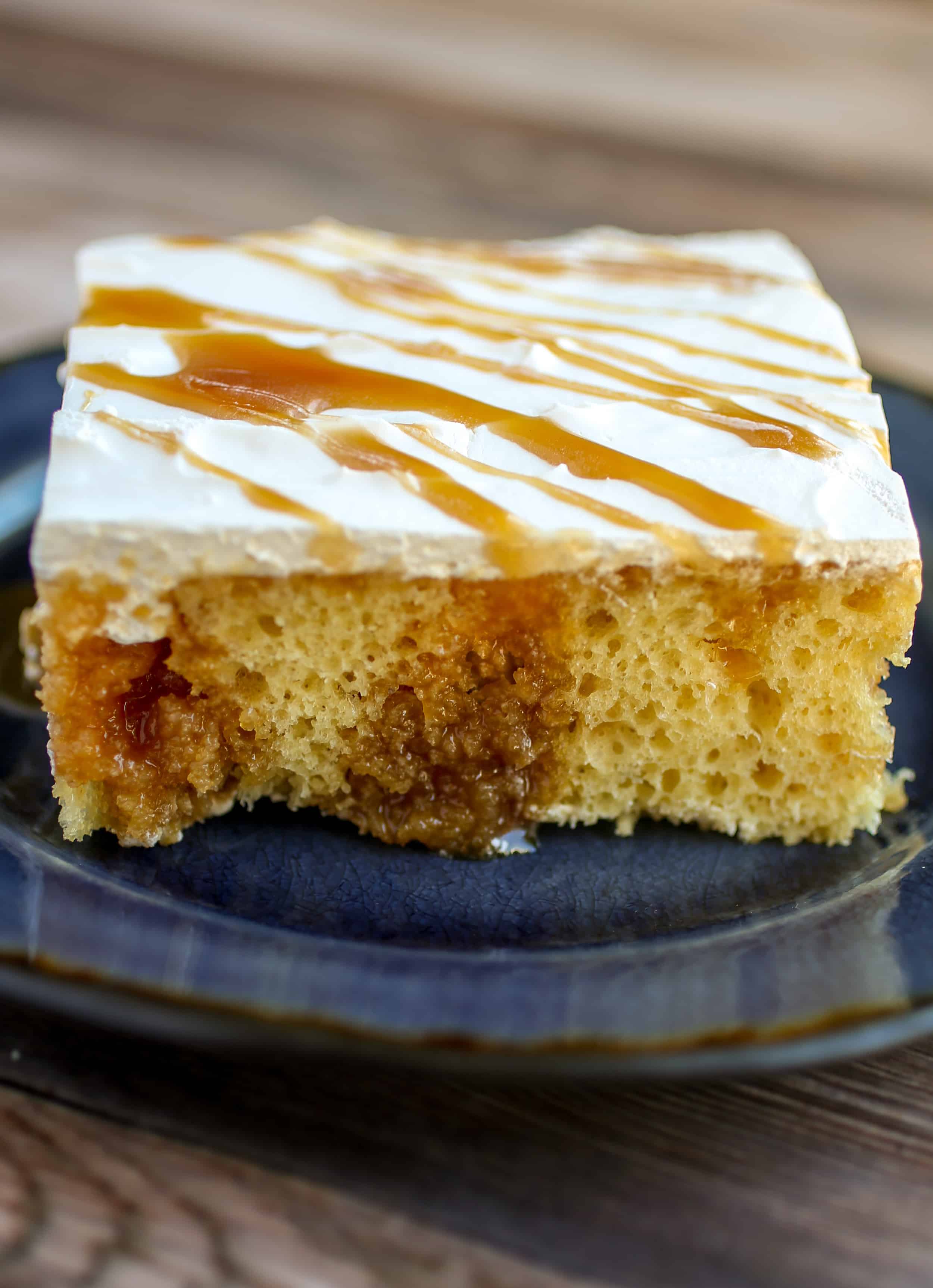 Caramel Poke Cake - Light and fluffy yellow cake filled with gooey caramel and topped with a sweet whipped topping!
