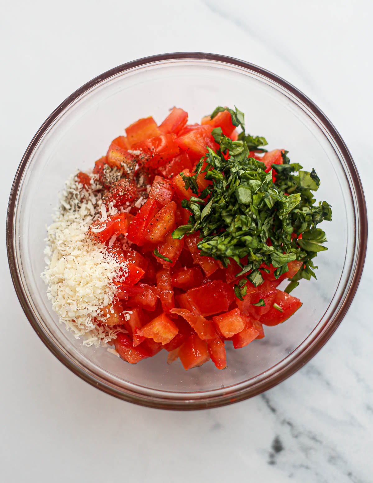Bruschetta ingredients in a bowl before mixing.