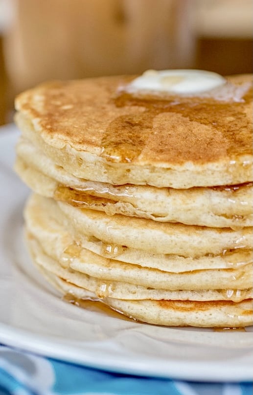 Perfect Buttermilk Pancakes stack with butter melting on top and syrup dripping down the sides.