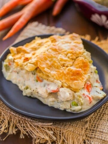 Slice of creamy chicken pot pie on a black plate