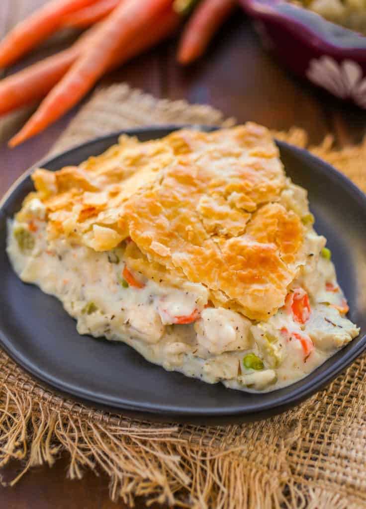 Slice of creamy chicken pot pie on a black plate