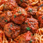 Meatballs in sauce on a bed of spaghetti.