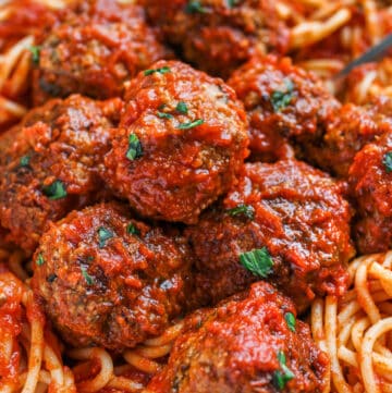 Meatballs in sauce on a bed of spaghetti.