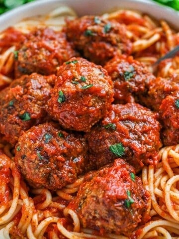 Meatballs in sauce on a bed of spaghetti.