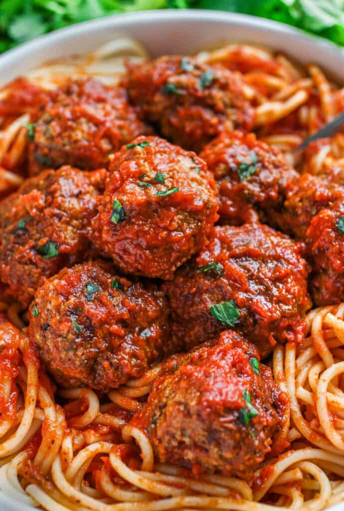 Meatballs in sauce on a bed of spaghetti.