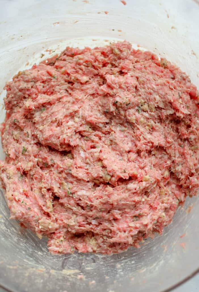 Raw meatball meat mixed in bowl.