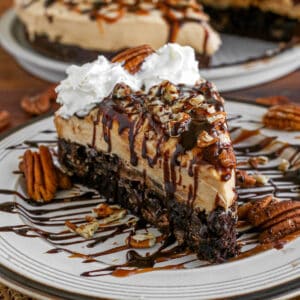 Caramel turtle cheesecake slice on a plate.