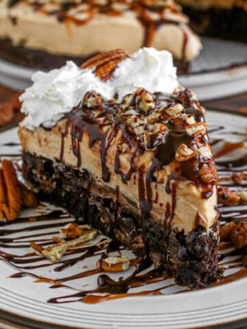 Caramel turtle cheesecake slice on a plate.