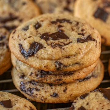 Stack of chocolate chip cookies on a cooling rack.
